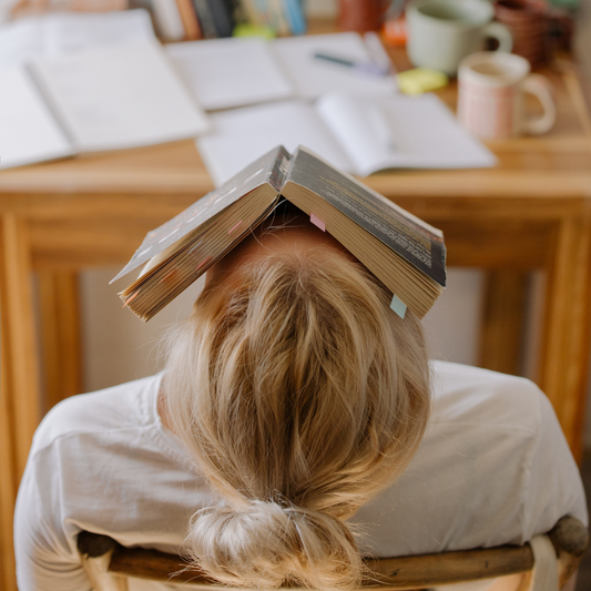 Gestresste Frau mit Buch auf Gesicht